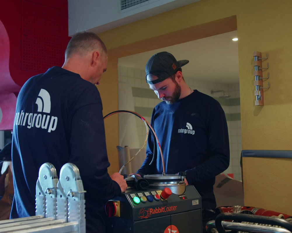Zwei Handwerker im Gespräch, symbolisieren die Werte und Expertise der RG Rohrgroup GmbH.